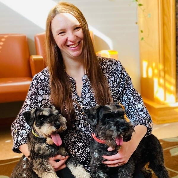 Woman holding two dogs and smiling